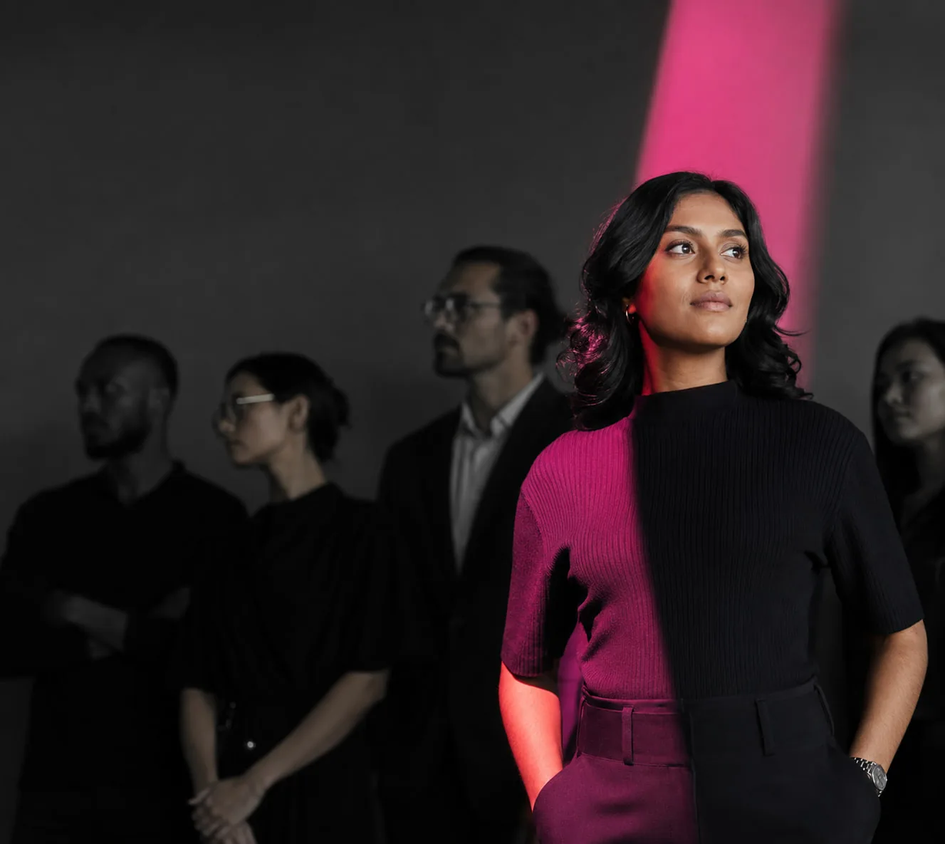 A confident professional standing with a diverse team